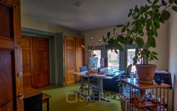 Sfeervol ingerichte kantoorruimte met bureau en uitzicht op Amsterdam Centrum, gelegen aan Oudebrugsteeg 9.