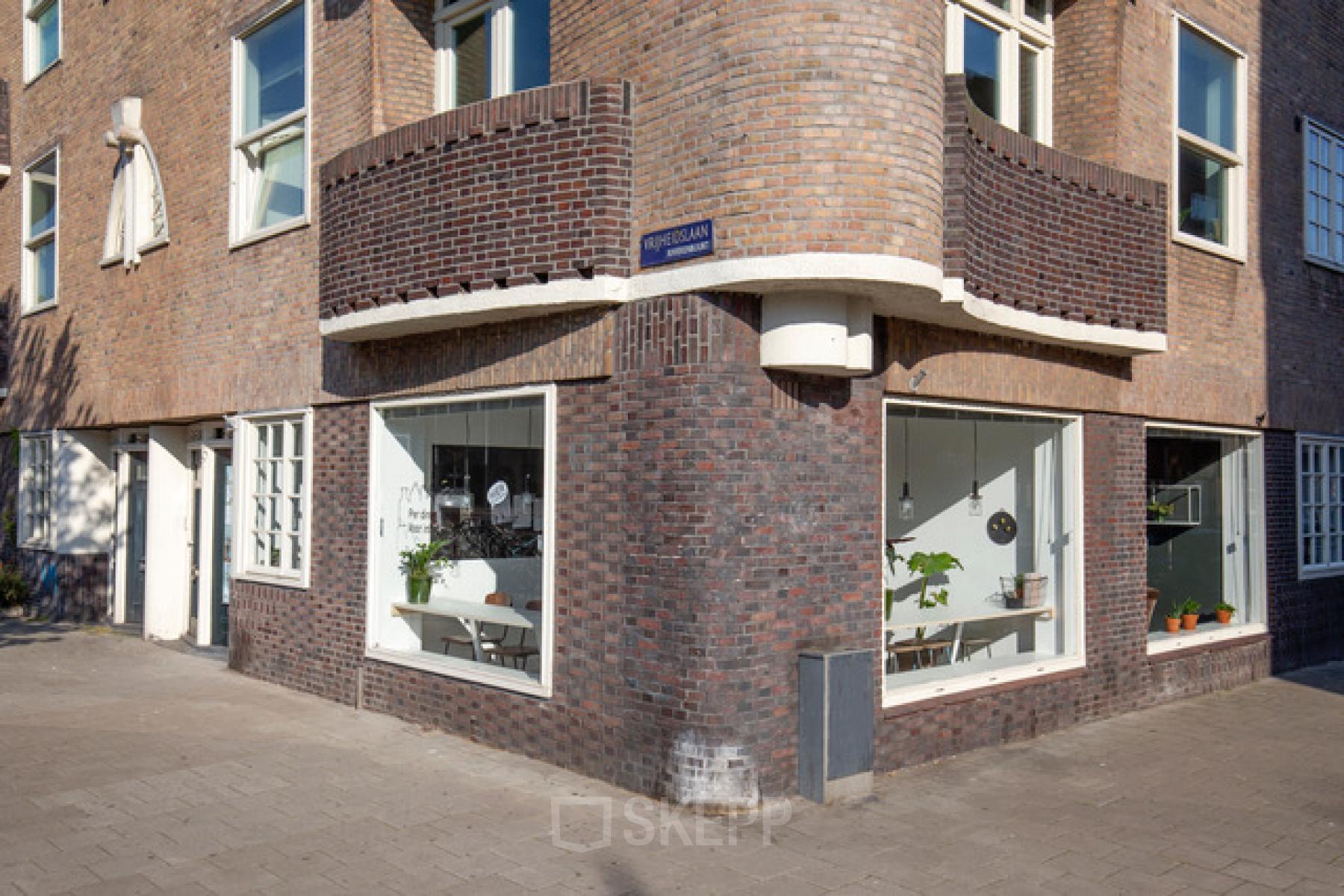 Bakstenen hoekpand op Vrijheidslaan 80 in Amsterdam De Pijp. Grote ramen bieden inzicht in de functies van het gebouw en zijn ideaal voor een kantoor.