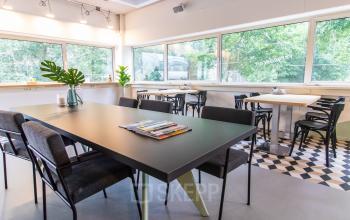 Moderne, lichte kantoorruimte op de Anthony Fokkerweg 1 in Amsterdam De Schinkel met een grote vergadertafel en stoelen.