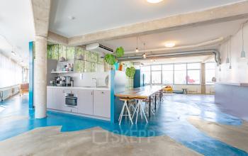 Kantoorruimte huren aan Generaal Vetterstraat 77e in Amsterdam De Schinkel, met open werkruimte, lange houten tafel en ingebouwde keuken.