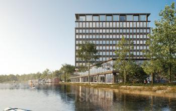 Modern kantoorpand aan Rijnsburgstraat 9-11, Amsterdam De Schinkel, met uitzicht op water en omgeven door groen. Mensen peddelen op het water voor een ontspannen sfeer.