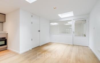 Lichte, minimalistische kantoorruimte huren op Schinkelkade 44 in Amsterdam De Schinkel met houten vloer en ingebouwde keukenhoek.