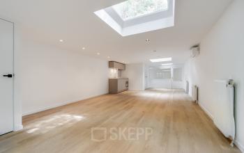 Lichte kantoorruimte te huur op Schinkelkade 44 in Amsterdam De Schinkel met een open vloer, houten vloer en een kitchenette onder dakramen.