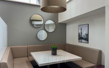 Gezellige kantoorruimte op Daalwijkdreef 47 in Amsterdam Duivendrecht met een hoekbank en een tafel, perfect om te huren voor informele meetings of lunches.