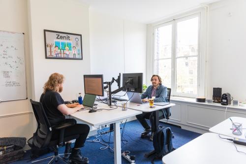 Kantoorpand aan Herengracht 420 in Amsterdam Grachtengordel met twee personen achter computers werkend aan een bureau.