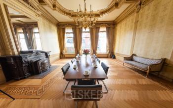 Vergaderruimte in een kantoorpand aan de Keizersgracht 482, Amsterdam Grachtengordel, met houten vloer, lange vergadertafel, stoelen, en een klassiek interieur.
