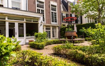 Exterieur van het kantoorpand aan Keizersgracht 482, Amsterdam Grachtengordel met tuin en metalen kunstwerk.