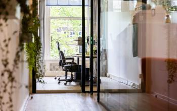 Kantoorruimte huren op Keizersgracht 482 in Amsterdam Grachtengordel. Vergaderruimte met glazen wanden, moderne stoelen en natuurlijke lichtinval door grote ramen.