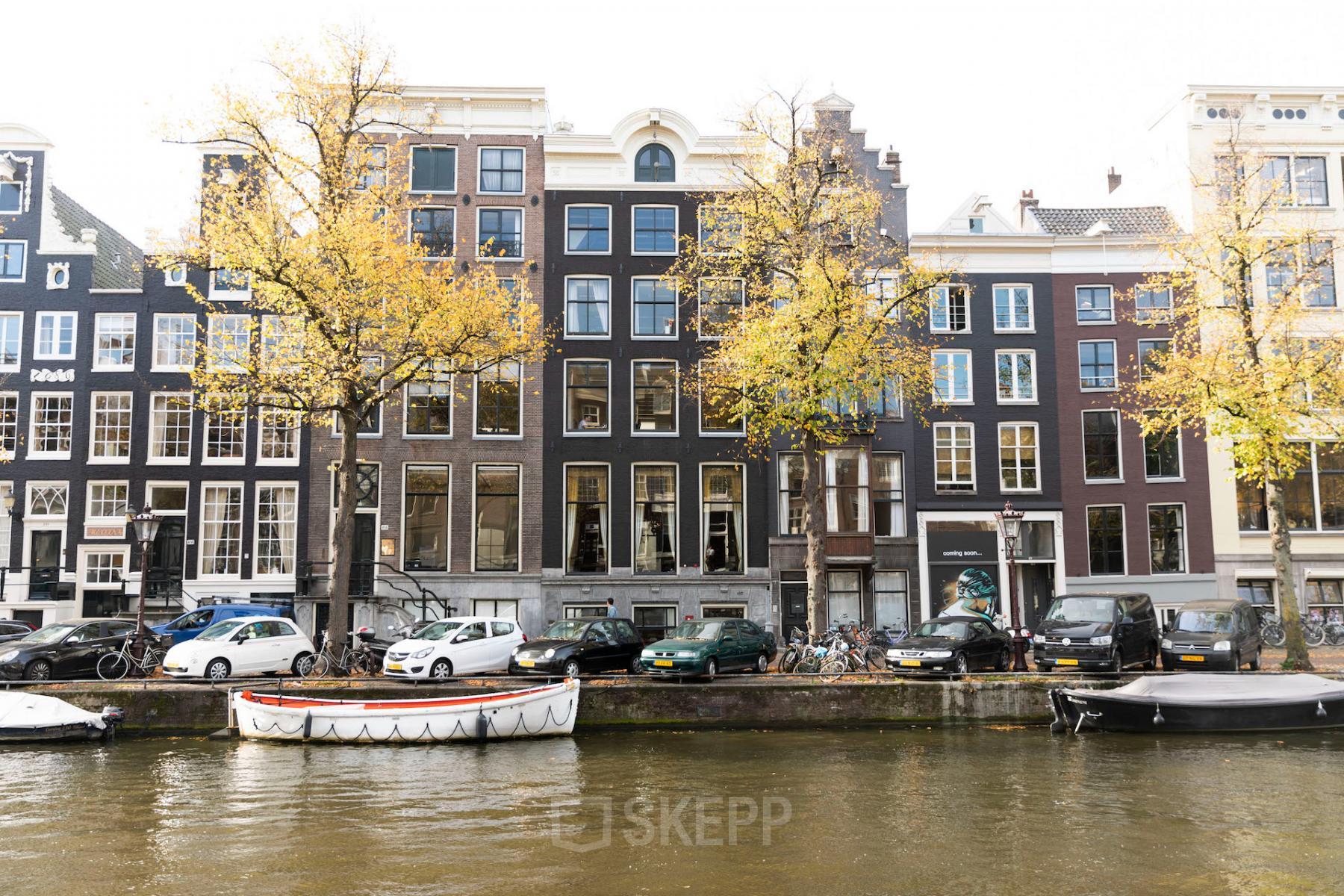 Kantoorpand aan de Keizersgracht 482 in de Amsterdam Grachtengordel, gezien vanaf de gracht met auto's en fietsen geparkeerd voor het gebouw.