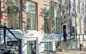 Exterieur van het kantoorpand aan Keizersgracht 62-64 in Amsterdam Grachtengordel met fietsen langs de gevel.