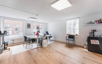 Een lichte, gemeubileerde kantoorruimte aan de Herengracht 221 in Amsterdam Grachtengordel met moderne bureaus en stoelen. Ideaal voor wie een kantoor wil huren in een historisch pand.