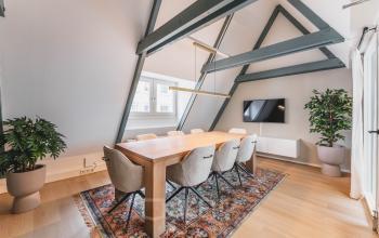 Moderne en lichte vergaderruimte met een lange houten tafel en comfortabele stoelen in een kantoorpand op Herengracht 221, Amsterdam Grachtengordel.