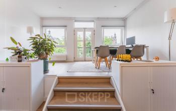 Kantoorruimte aan de Herengracht 221 in Amsterdam Grachtengordel met uitzicht op de gracht. De ruimte is gemeubileerd met een tafel, stoelen en planten, ideaal voor kantoorruimte huren.