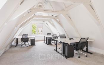 Lichte en ruime kantoorruimte aan de Herengracht 221 in Amsterdam Grachtengordel, voorzien van bureaus en stoelen. Deze open werkruimte biedt een uitnodigende omgeving voor bedrijven die een kantoorpand willen huren.