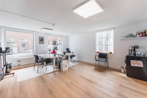 Een lichte, gemeubileerde kantoorruimte aan de Herengracht 221 in Amsterdam Grachtengordel met moderne bureaus en stoelen. Ideaal voor wie een kantoor wil huren in een historisch pand.