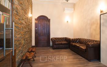 Stijlvolle kantoorruimte met klassieke leren banken en houten vloer op Herengracht 282, ideaal voor ondernemers die een kantoor willen huren in Amsterdam Grachtengordel.