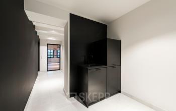 Interieur van kantoorpand aan Keizersgracht 119, Amsterdam Grachtengordel. Open ruimte met donkere kast, lichte vloeren en toegang tot een andere kamer. Geschikt voor kantoorruimte huren.