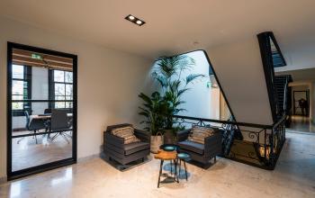 Ruime, moderne ontvangstruimte op Keizersgracht 119, Amsterdam Grachtengordel met stijlvolle meubels en groenaccenten, ideaal voor wie kantoorruimte wil huren.