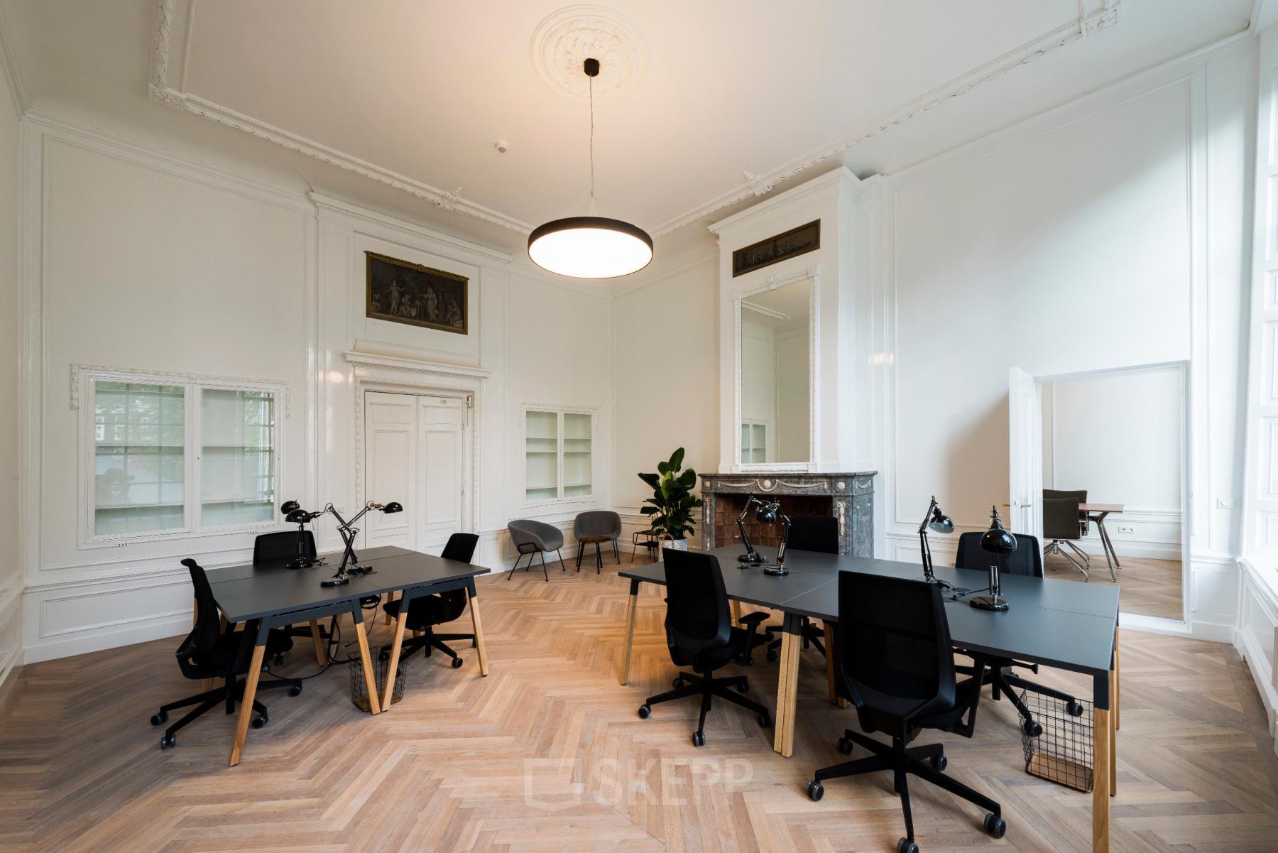 Kantoorruimte huren aan de Keizersgracht 119 in Amsterdam Grachtengordel met moderne inrichting en lichte muren, voorzien van bureaus en stoelen in een open werkruimte.
