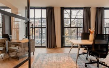 Kantoorruimte aan Keizersgracht 121 in Amsterdam Grachtengordel, met grote ramen, moderne meubels en uitzicht op de gracht, geschikt om te huren voor een zakelijke omgeving.