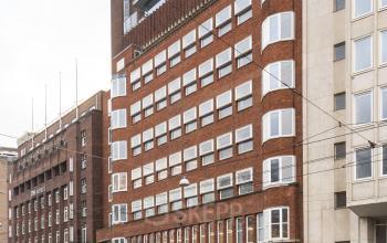 Kantoorpand aan de Stadhouderskade 5-6 in Amsterdam Grachtengordel, met een bakstenen gevel en afgeronde ramen. Ruim, functioneel gebouw ideaal voor kantoorruimte huren.
