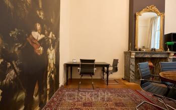 Kantoorruimte te huur op Keizersgracht 391A, Amsterdam, met klassieke inrichting, tapijt en kunstwerken aan de muur. Geschikt voor zakelijke activiteiten.