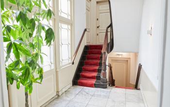 Entree van een kantoorpand aan de Keizersgracht 391A in Amsterdam Grachtengordel met marmeren vloer en rode traploper.