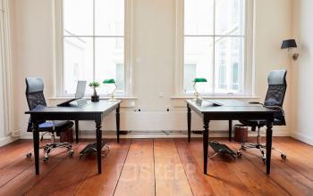 Kantoorruimte huren op Keizersgracht 391A in Amsterdam Grachtengordel met twee ruime bureaus, ergonomische stoelen en grote ramen voor veel natuurlijk licht.