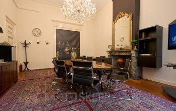 Stijlvolle vergaderruimte in een kantoorpand aan Keizersgracht 391A, Amsterdam Grachtengordel. Deze kantoorruimte huren biedt een elegante setting met moderne stoelen rond een grote tafel en een indrukwekkende kroonluchter.