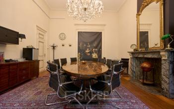 Kantoorruimte huren aan de Keizersgracht 391A in Amsterdam Grachtengordel met een elegante conferentieruimte, een houten tafel, moderne stoelen en een klassieke kroonluchter.