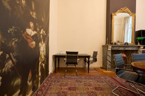 Kantoorruimte te huur op Keizersgracht 391A, Amsterdam, met klassieke inrichting, tapijt en kunstwerken aan de muur. Geschikt voor zakelijke activiteiten.