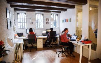 Kantoorpand op Vinkenstraat 79 HS, Amsterdam Grachtengordel met drie werkende personen in een open kantoorruimte.