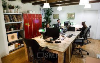 Kantoorruimte huren op Vinkenstraat 79 HS in Amsterdam Grachtengordel met werkplekken, computers en mensen bezig aan bureaus.