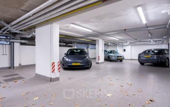 Parkeergarage van het kantoorpand op Keizersgracht 452, Amsterdam Grachtengordel met geparkeerde auto's.