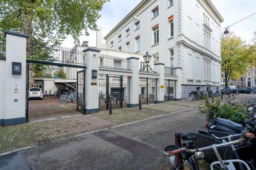 Voorzijde van kantoorpand op Keizersgracht 452 in Amsterdam Grachtengordel met fietsenstalling en parkeerplek.