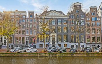 Gevel van het kantoorpand op Keizersgracht 572 in Amsterdam Grachtengordel, met klassieke architectuur en rij geparkeerde auto's langs de gracht. Ideaal voor kantoorruimte huren in een iconische omgeving.