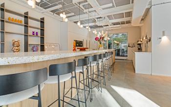 Moderne kantoorruimte huren aan de Keizersgracht 572-572, Amsterdam Grachtengordel met een stijlvolle lange bar en royale zitgelegenheid. De ruimte is voorzien van trendy verlichting en decoratieve elementen, ideaal voor informeel overleg.