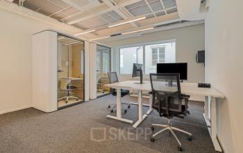 Moderne kantoorruimte huren op Keizersgracht 572 in Amsterdam Grachtengordel, met glazen vergadercabines en strakke bureaus, geschikt voor productief werken.