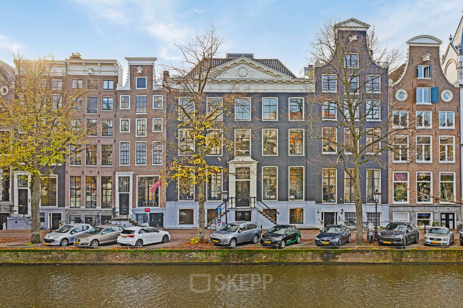 Gevel van het kantoorpand op Keizersgracht 572 in Amsterdam Grachtengordel, met klassieke architectuur en rij geparkeerde auto's langs de gracht. Ideaal voor kantoorruimte huren in een iconische omgeving.