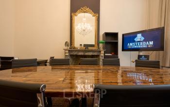 Vergaderruimte in kantoorpand op Keizersgracht 391A, Amsterdam Grachtengordel, met elegante houten tafel, chique spiegel en moderne stoelen. Ideaal voor bedrijven die kantoorruimte huren.