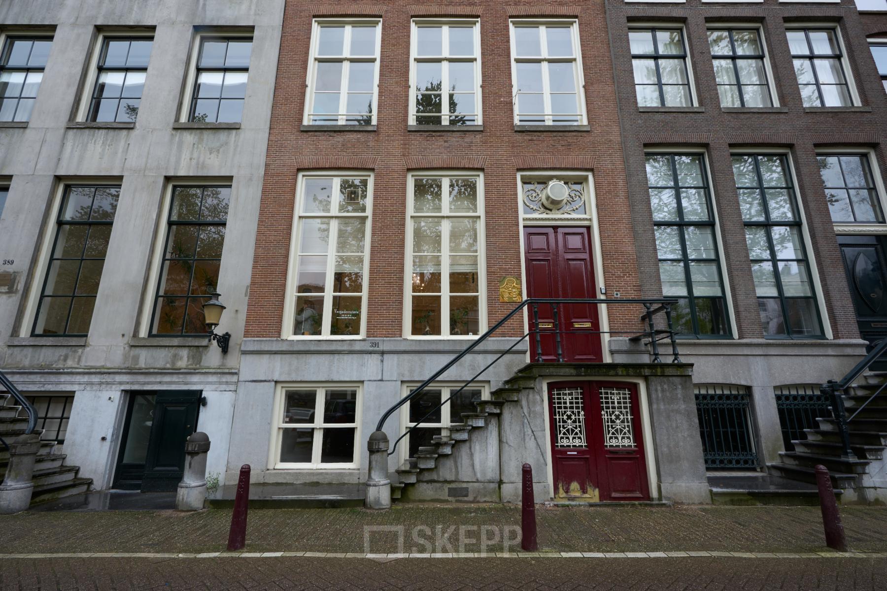 Buitenkant van het kantoorpand gelegen op Keizersgracht 391A in Amsterdam Grachtengordel. Het historische gebouw heeft grote ramen en een klassieke rode deur, ideaal voor wie kantoorruimte wil huren.