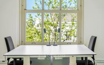 Lichte kantoorruimte met twee bureaus en stoelen voor het raam aan de Keizersgracht 261, Amsterdam Grachtengordel. Ideaal voor kantoorruimte huren.