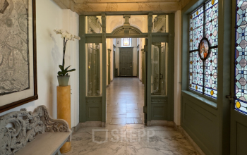 Entree van het historische kantoorpand aan Keizersgracht 261, Amsterdam Grachtengordel, met glas-in-lood ramen en marmeren vloeren. Perfect om kantoorruimte te huren in het hart van de stad.