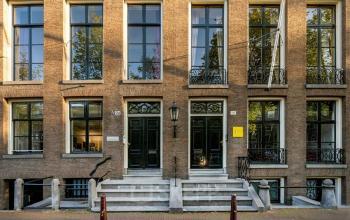 Vooraanzicht van kantoorpand aan de Herengracht 582-584 in Amsterdam Grachtengordel met karakteristieke gevels en grote ramen.