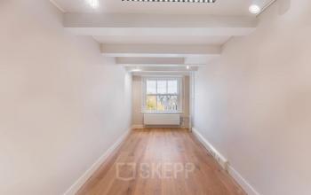 Lichte kantoorruimte aan de Herengracht 582-584 in de Amsterdam Grachtengordel, met houten vloer en grote ramen voor natuurlijk licht. Ideale plek voor je volgende kantoorhuren avontuur.