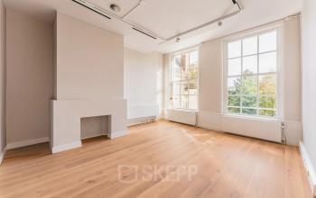 Lichte kantoorruimte te huur aan de Herengracht 582-584 in Amsterdam Grachtengordel, met houten vloer en grote ramen voor veel natuurlijk licht.