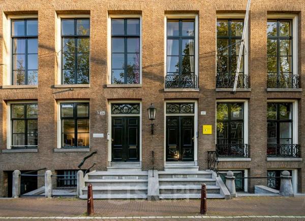 Vooraanzicht van kantoorpand aan de Herengracht 582-584 in Amsterdam Grachtengordel met karakteristieke gevels en grote ramen.
