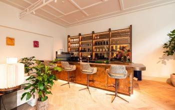 Modern ingerichte lounge met een stijlvolle bar, planten en comfortabele zitjes in een kantoorpand aan de Keizersgracht 264 in Amsterdam Grachtengordel. Kantoorruimte huren met een eigentijdse uitstraling.