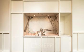 Stijlvolle keukenhoek in het kantoorpand aan de Keizersgracht 264 in Amsterdam Grachtengordel, met marmeren achterwand en moderne wite kasten. Ideaal voor kantoorruimte huren.