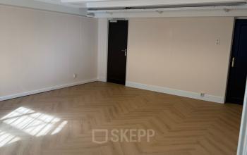 Lege kantoorruimte met houten vloer op Herengracht 493 in Amsterdam Grachtengordel, klaar om in te richten voor diverse zakelijke doeleinden.